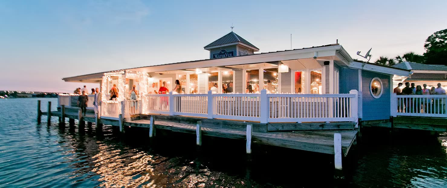 Waterfront wedding reception deck overlooking the Emerald Coast at sunset